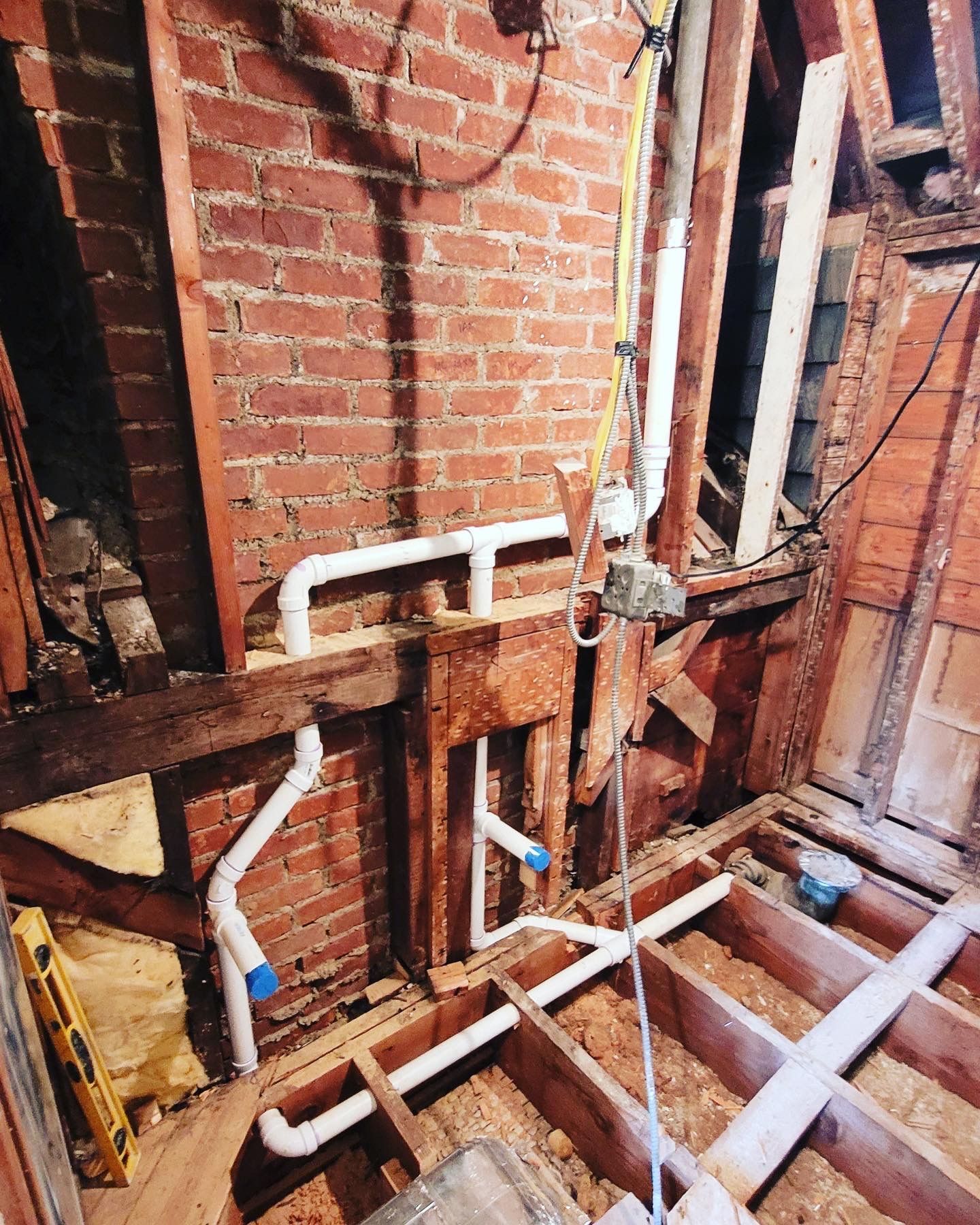 a bathroom under construction with a brick wall and wooden floor