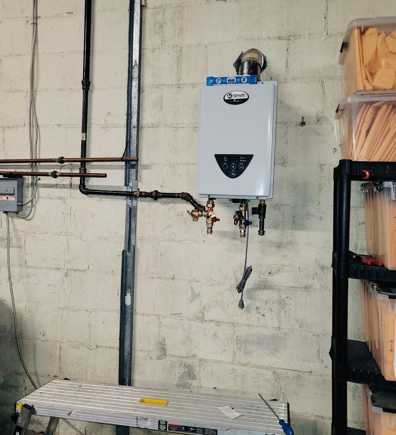 a white water heater is mounted to a brick wall