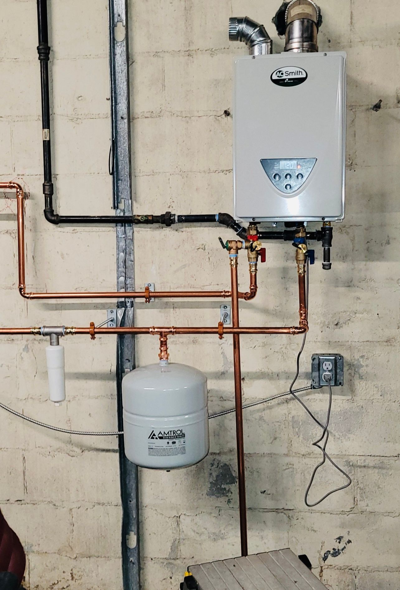 a white water heater is mounted to a brick wall