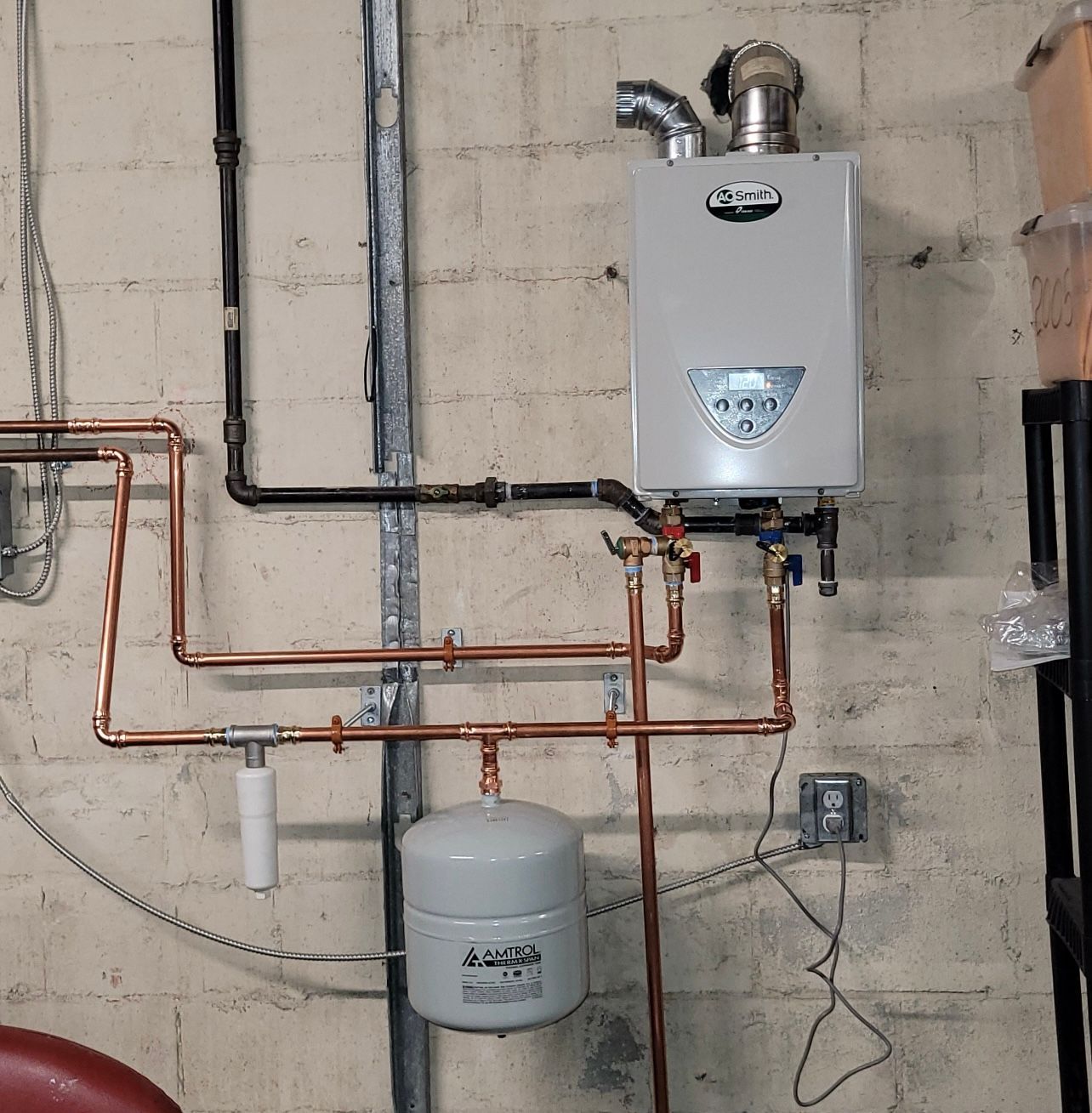 a water heater is mounted to a wall with copper pipes