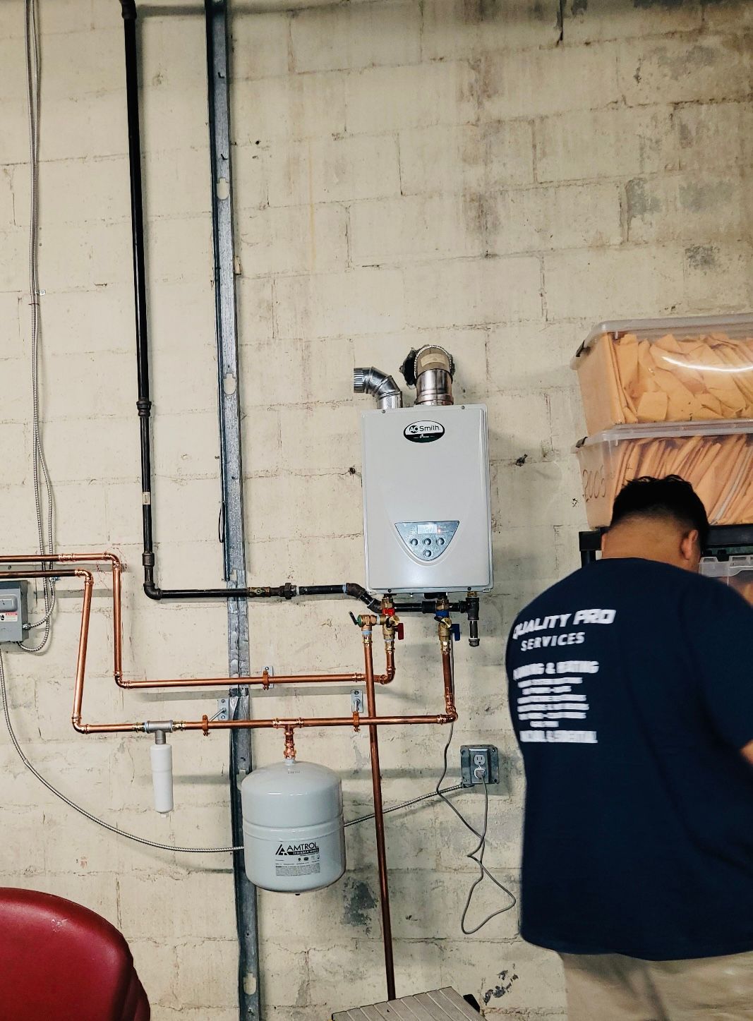 a man in a blue shirt is working on a water heater