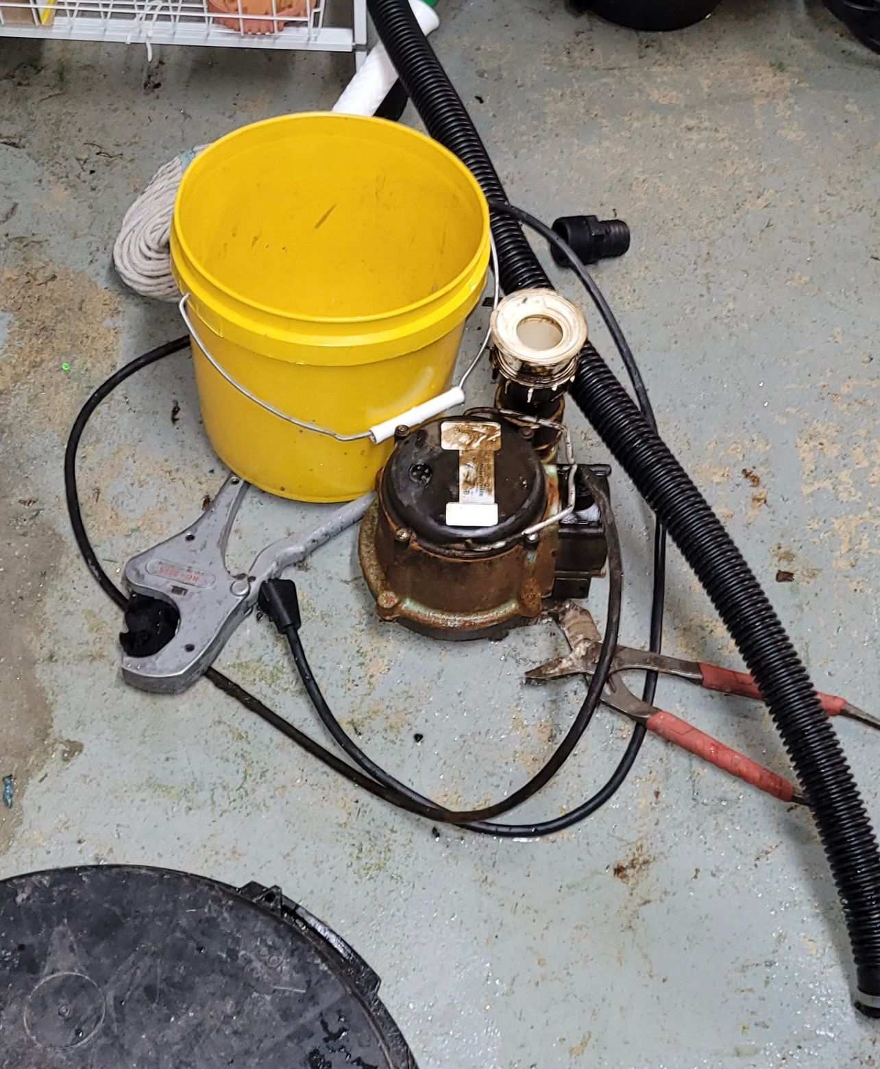 a yellow bucket is sitting on the floor next to a vacuum cleaner