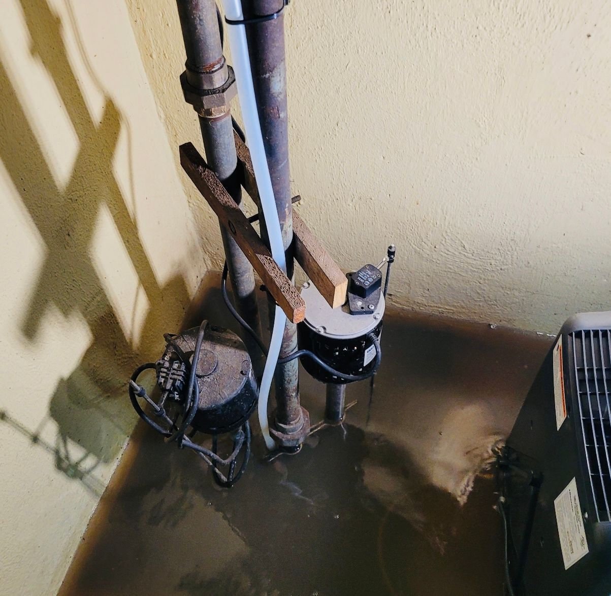 a water pump is sitting in a flooded basement next to a wall