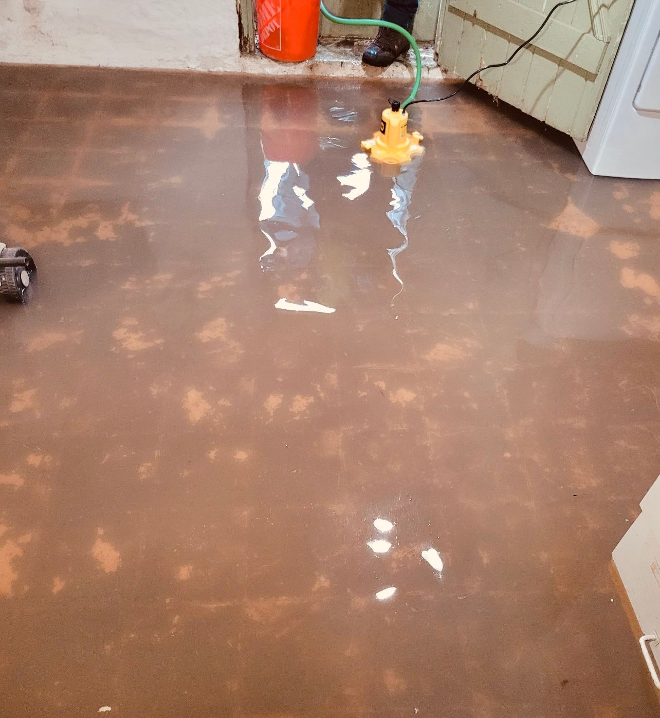 a person is cleaning a flooded floor with a hose
