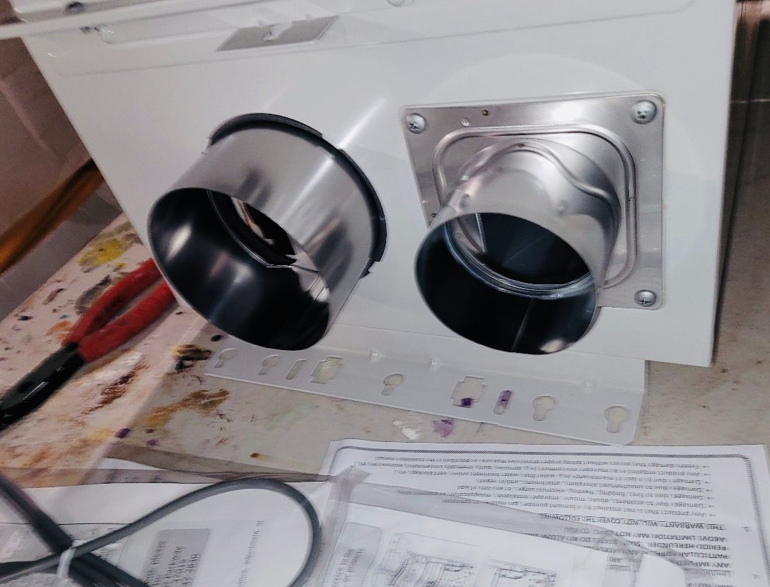 a pair of pliers sits next to a white box