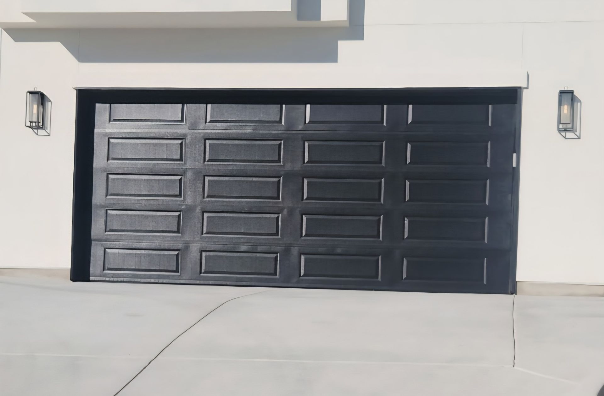 Black paneled garage door on a modern house exterior with wall-mounted lights