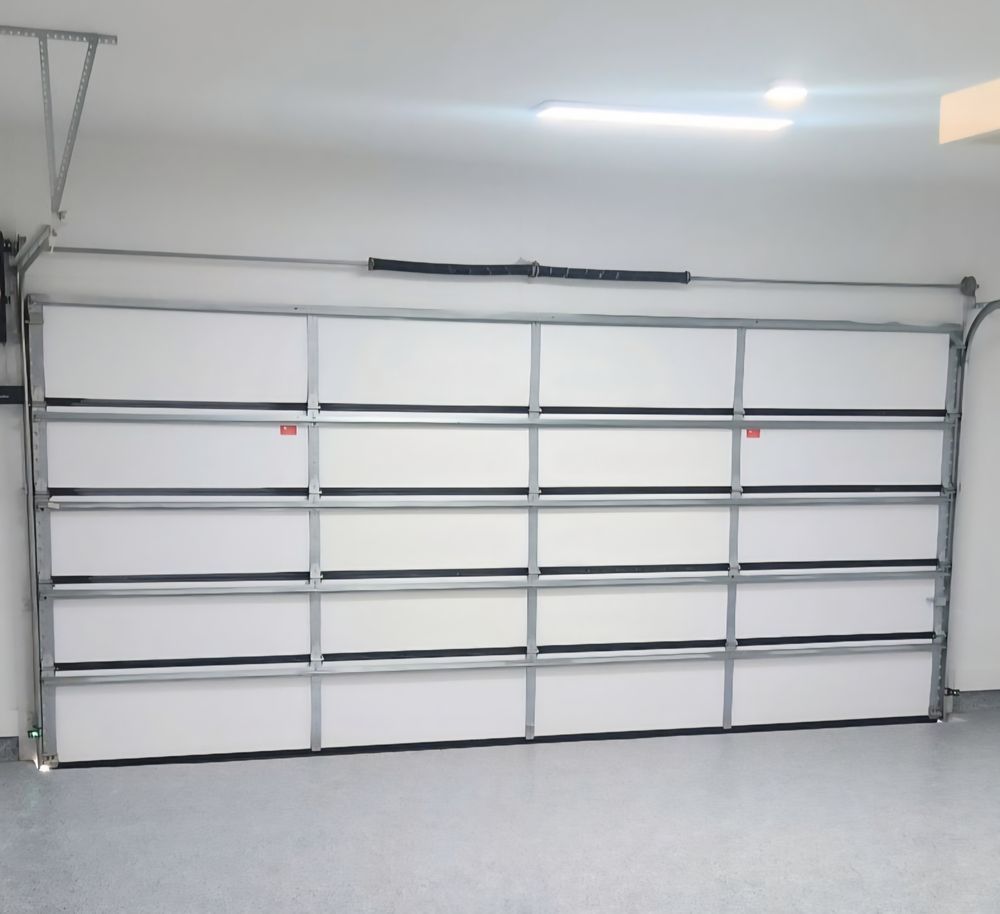 Closed white garage door in a clean, empty garage.