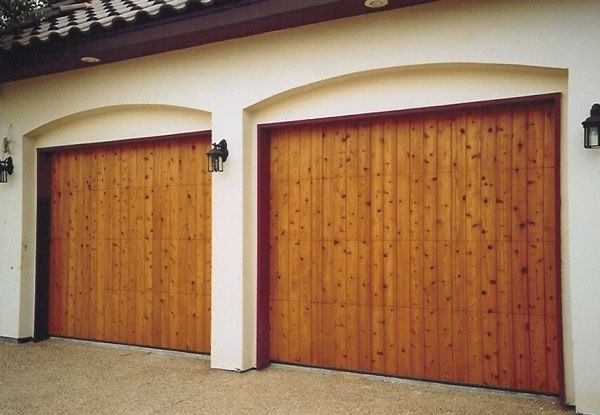 Two wooden garage doors in a stucco exterior wall
