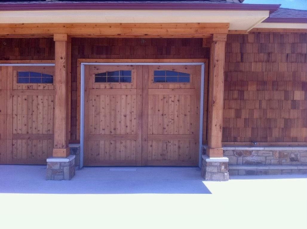Wooden building entrance with double doors and small windows under a roof overhang