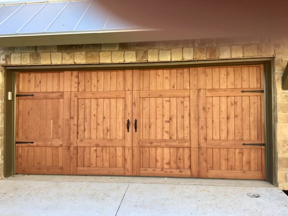 Double wooden garage doors set in a stone-and-stucco exterior wall