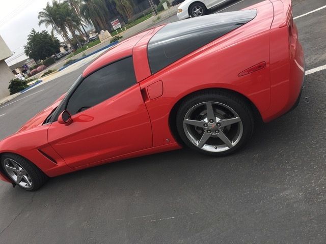 A red sports car is parked in a parking lot.