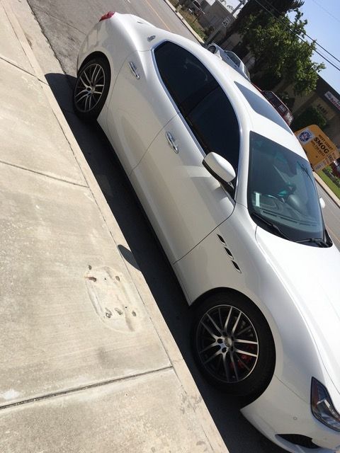 A white car is parked on the side of the road.