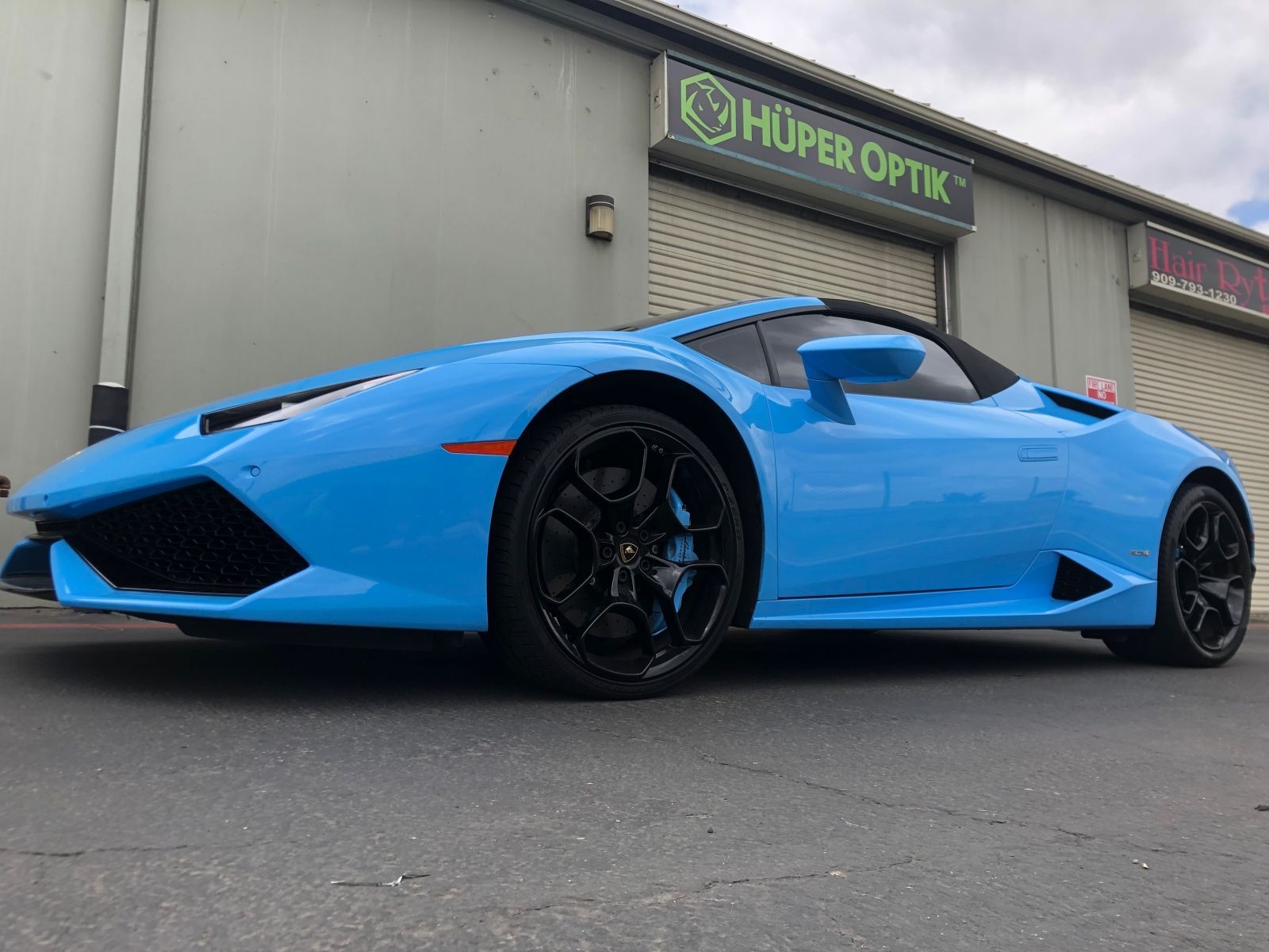 A blue lamborghini huracan is parked in front of a building.