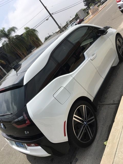 A white car is parked on the side of the road.