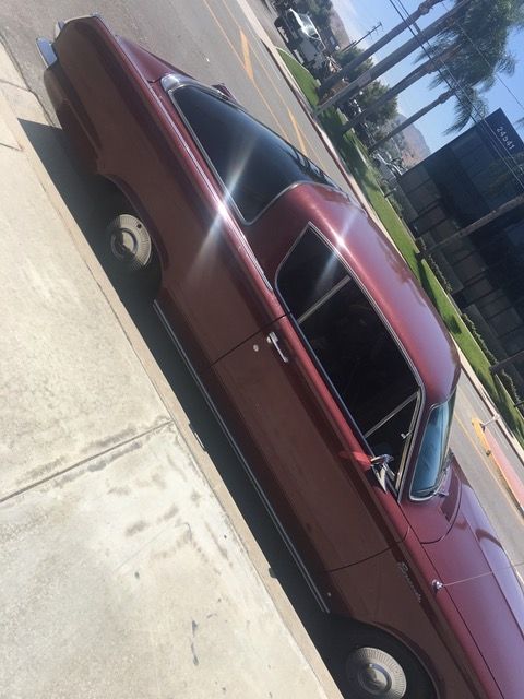 A red car is parked on the side of the road.