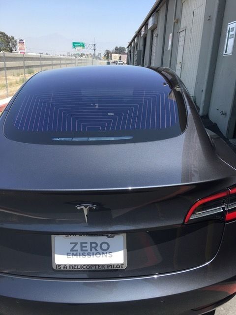 A tesla model s is parked in front of a building.