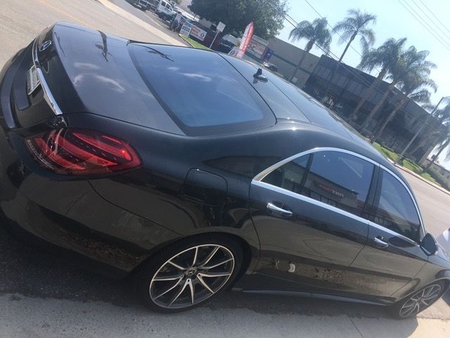A black car is parked on the side of the road.
