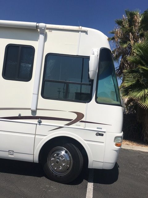 A white rv is parked in a parking lot.