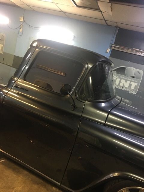A black pickup truck is parked in a garage.