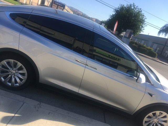 A silver car is parked on the side of the road.