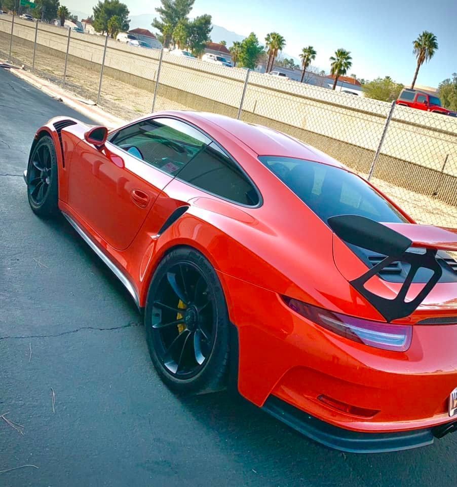 A red sports car is parked on the side of the road.