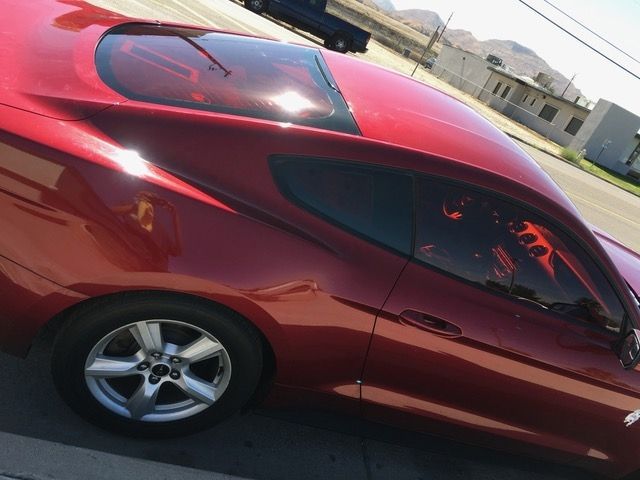 A red car is parked on the side of the road.