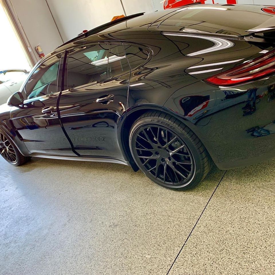 A black car is parked in a garage.