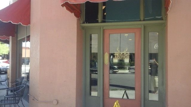 A pink building with a red awning and a pink door