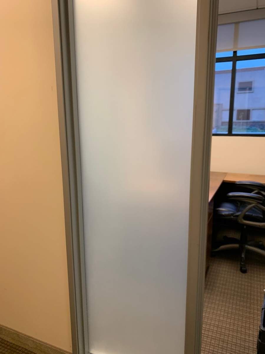 A doorway leading to a room with a desk and chairs.