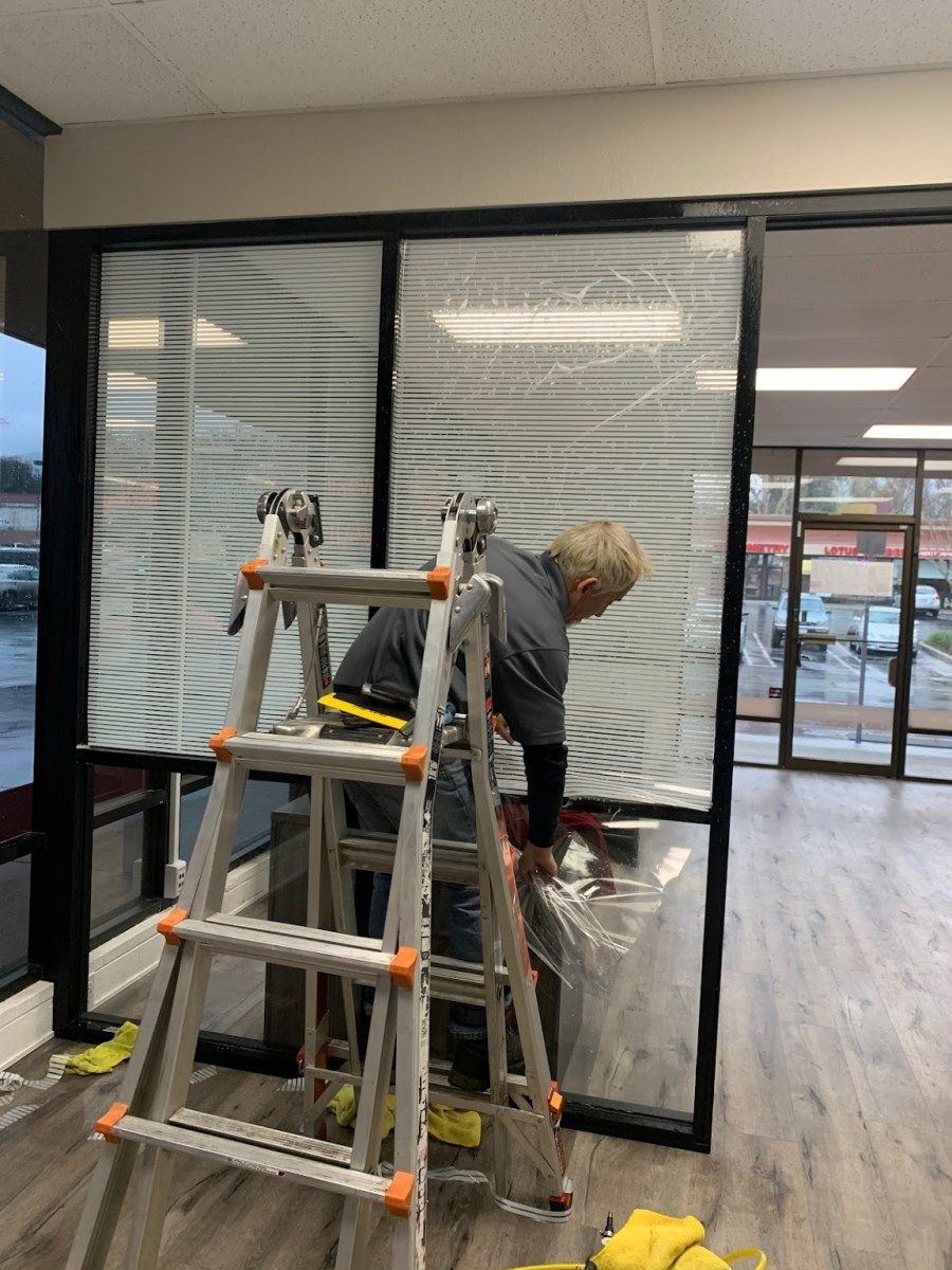 A man is standing on a ladder in a room.