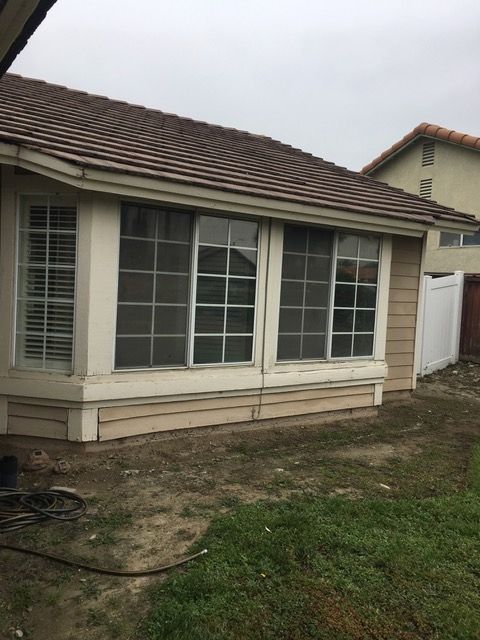 A house with a lot of windows and a white fence