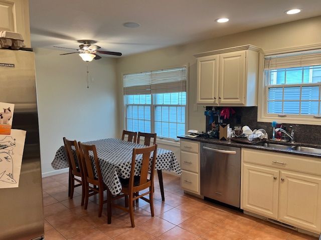 Kitchen with a table and chairs, cabinets, sink, and a refrigerator.