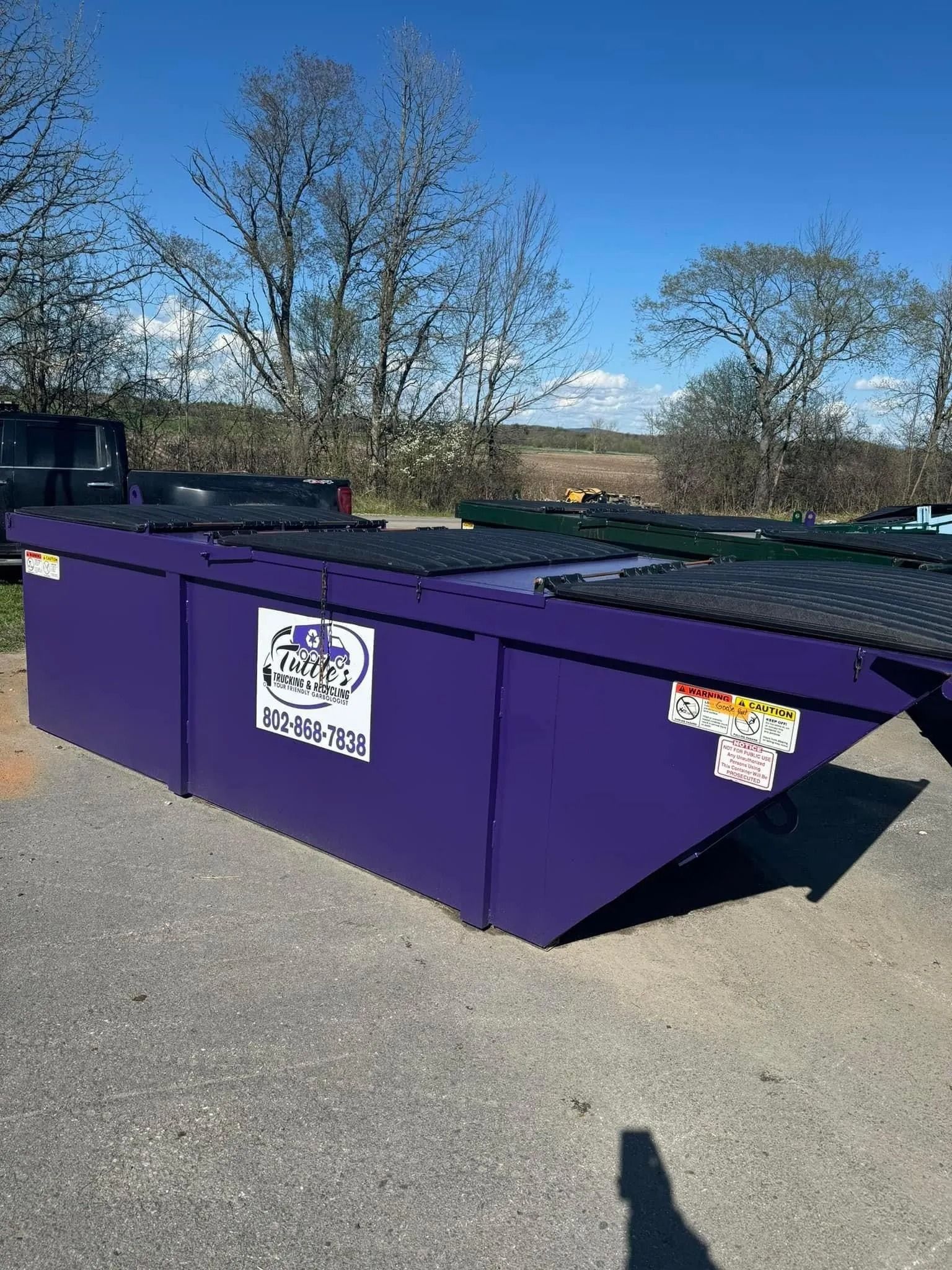 Purple commercial dumpster in an outdoor setting.