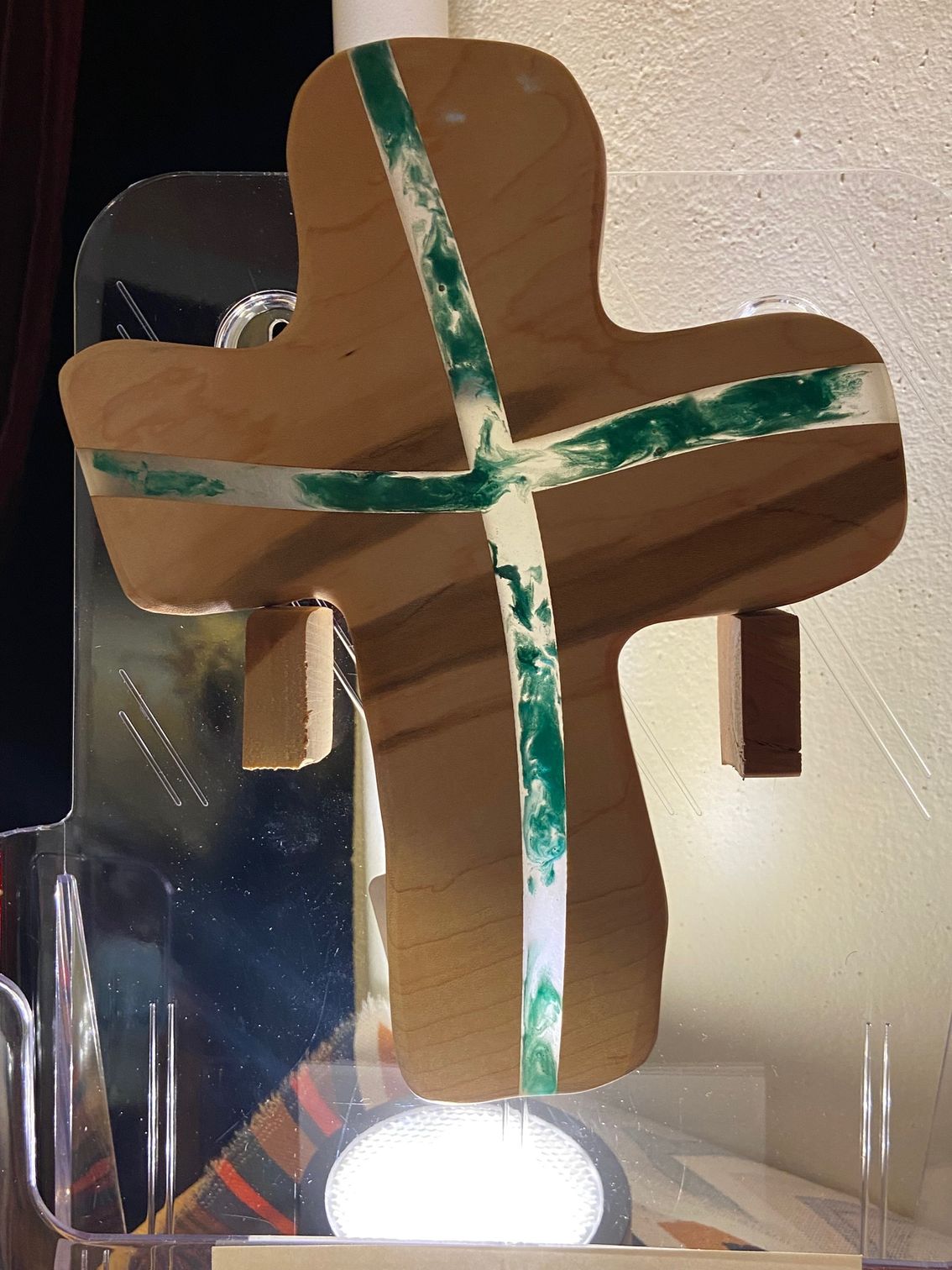 A wooden cross with a green stripe on it