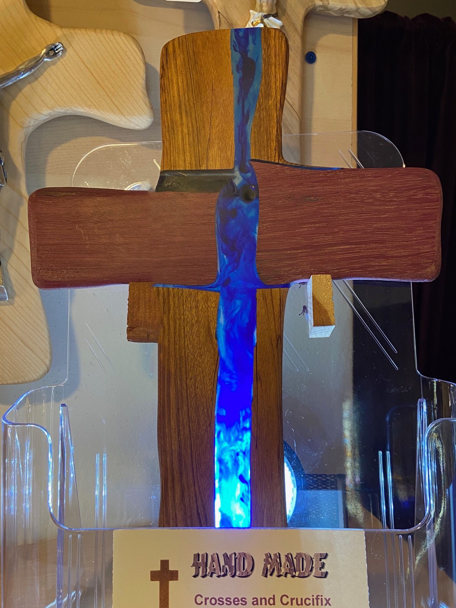 A wooden cross with a blue light inside of it