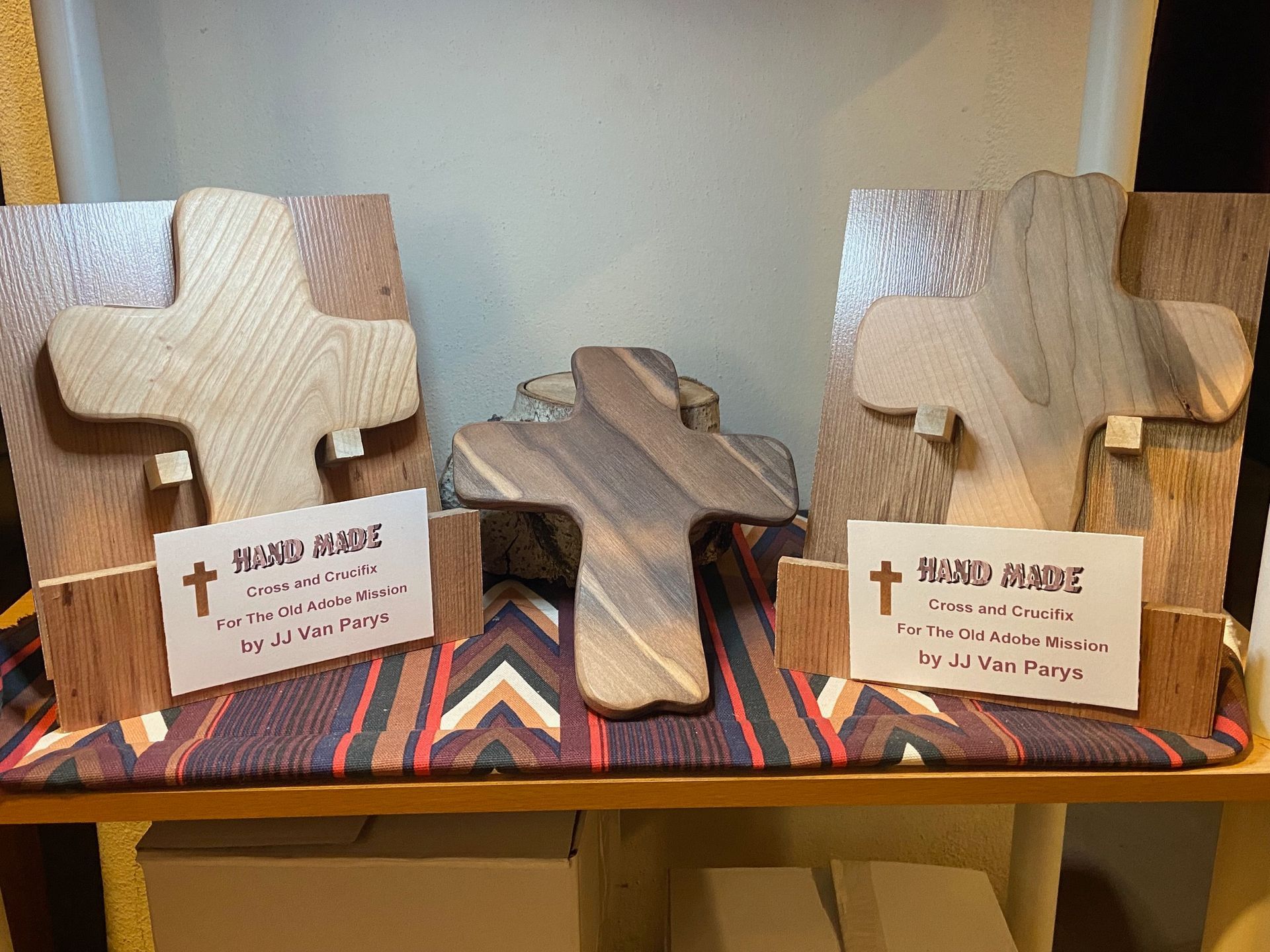 Three wooden crosses are on display on a shelf