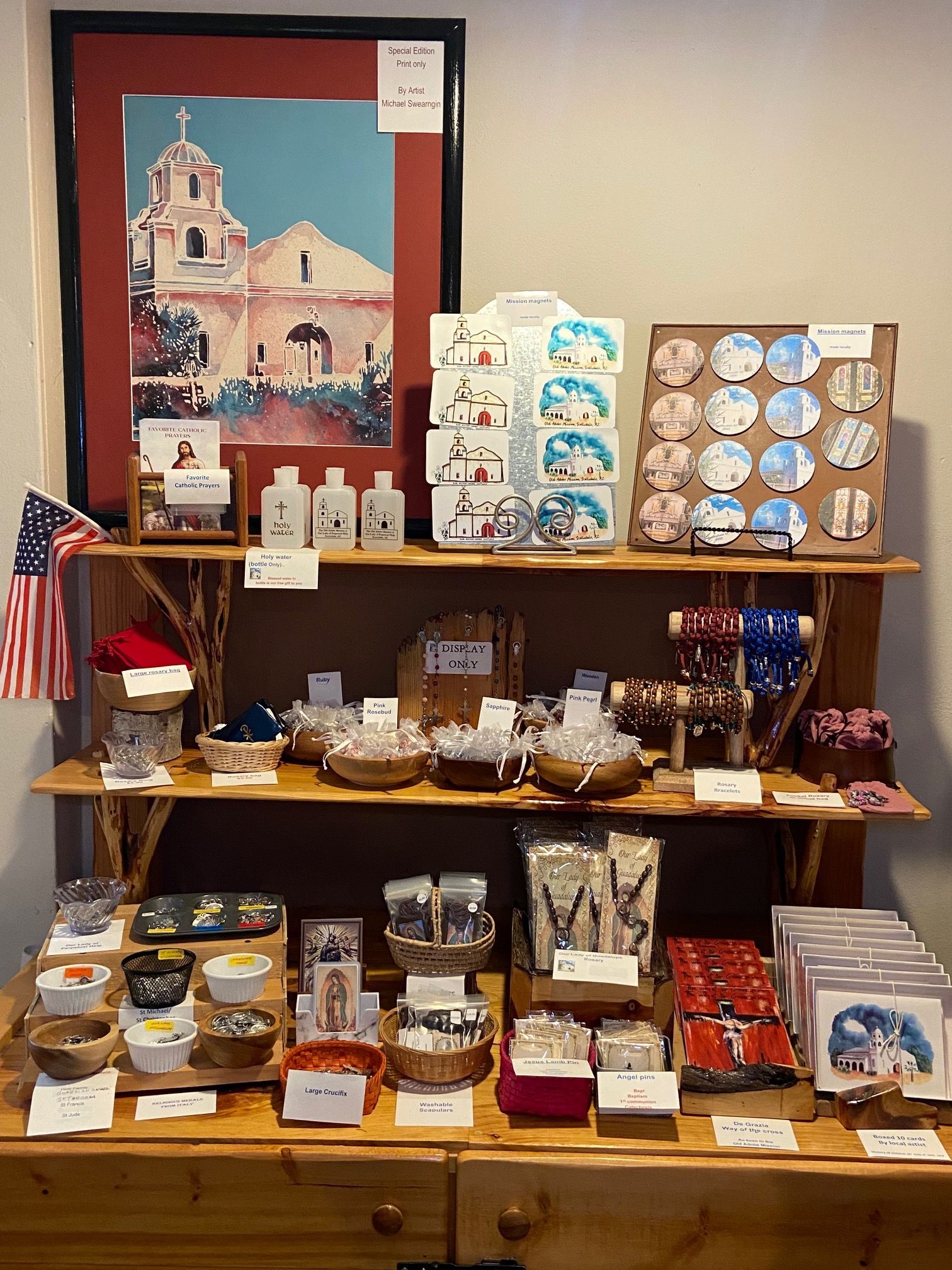 A wooden shelf filled with various items and a picture of a church.