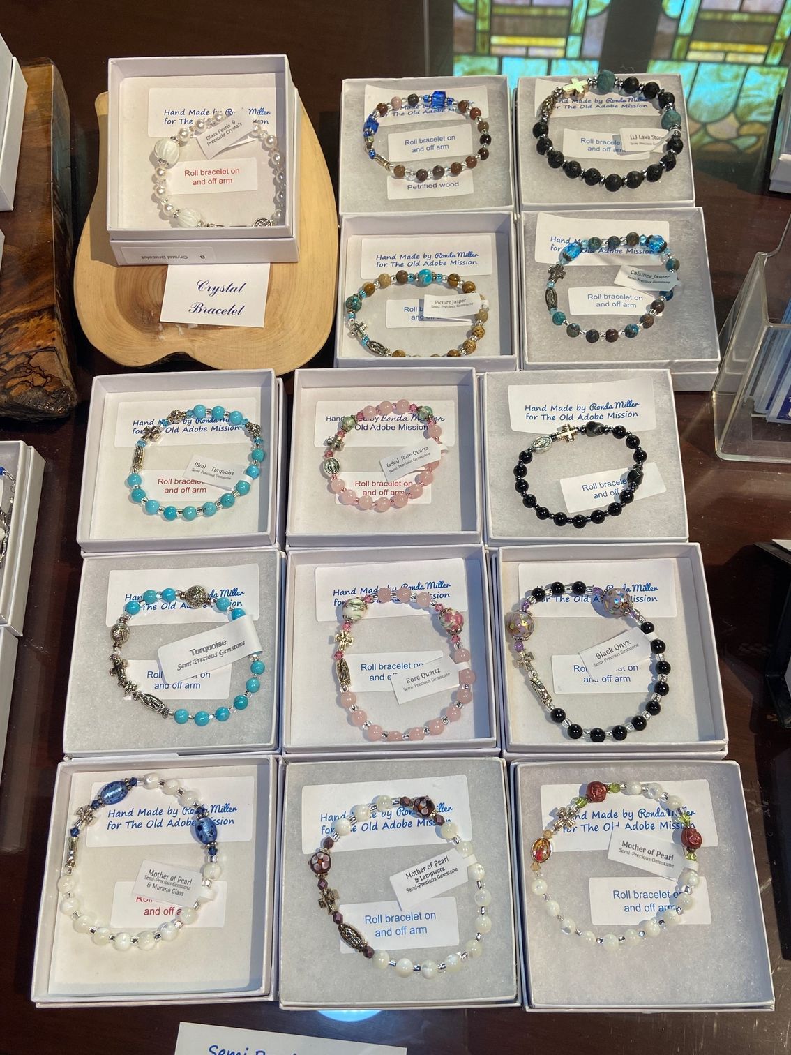 A variety of bracelets are displayed in boxes on a table.