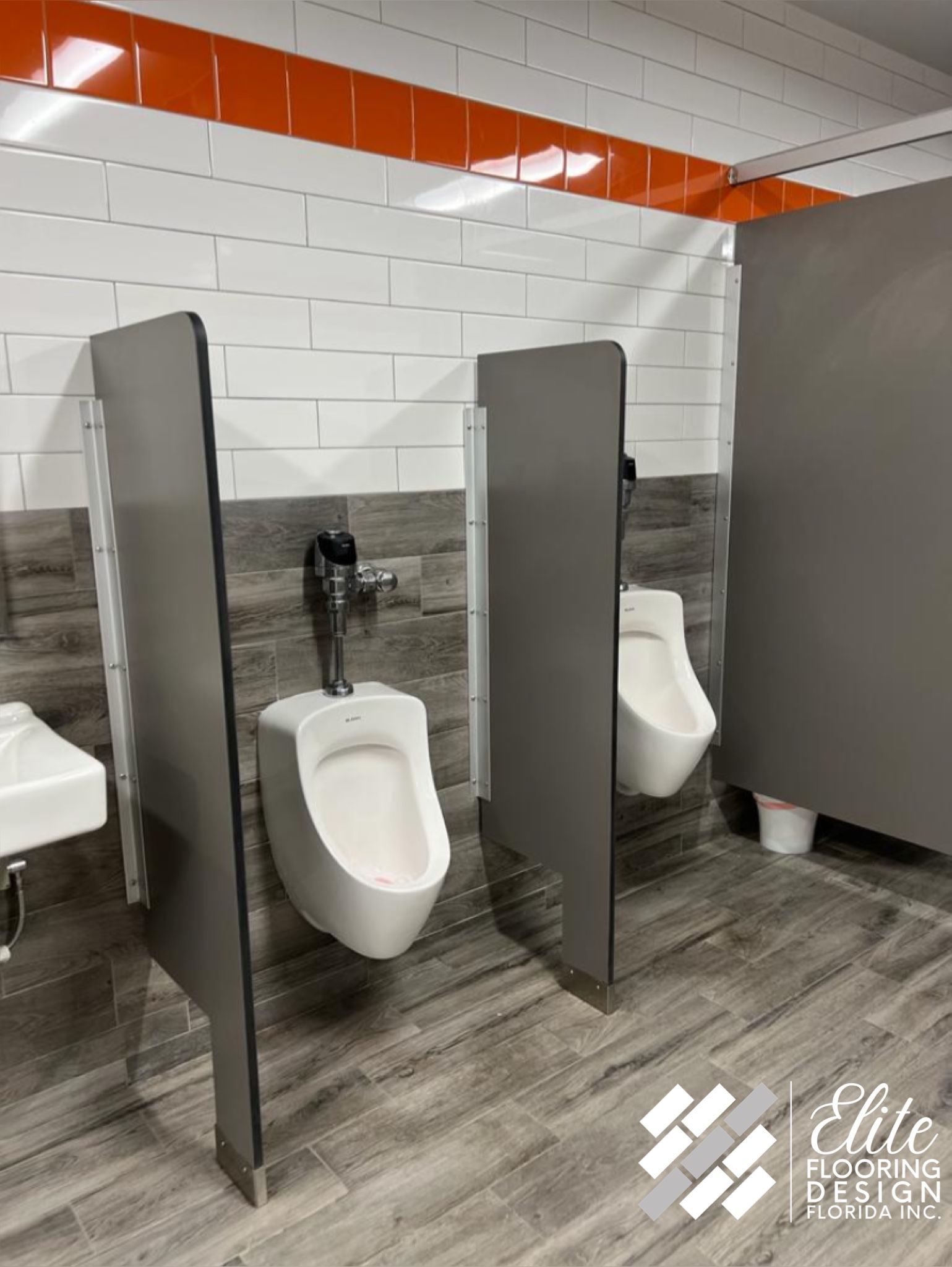 A bathroom with two urinals and a sink.