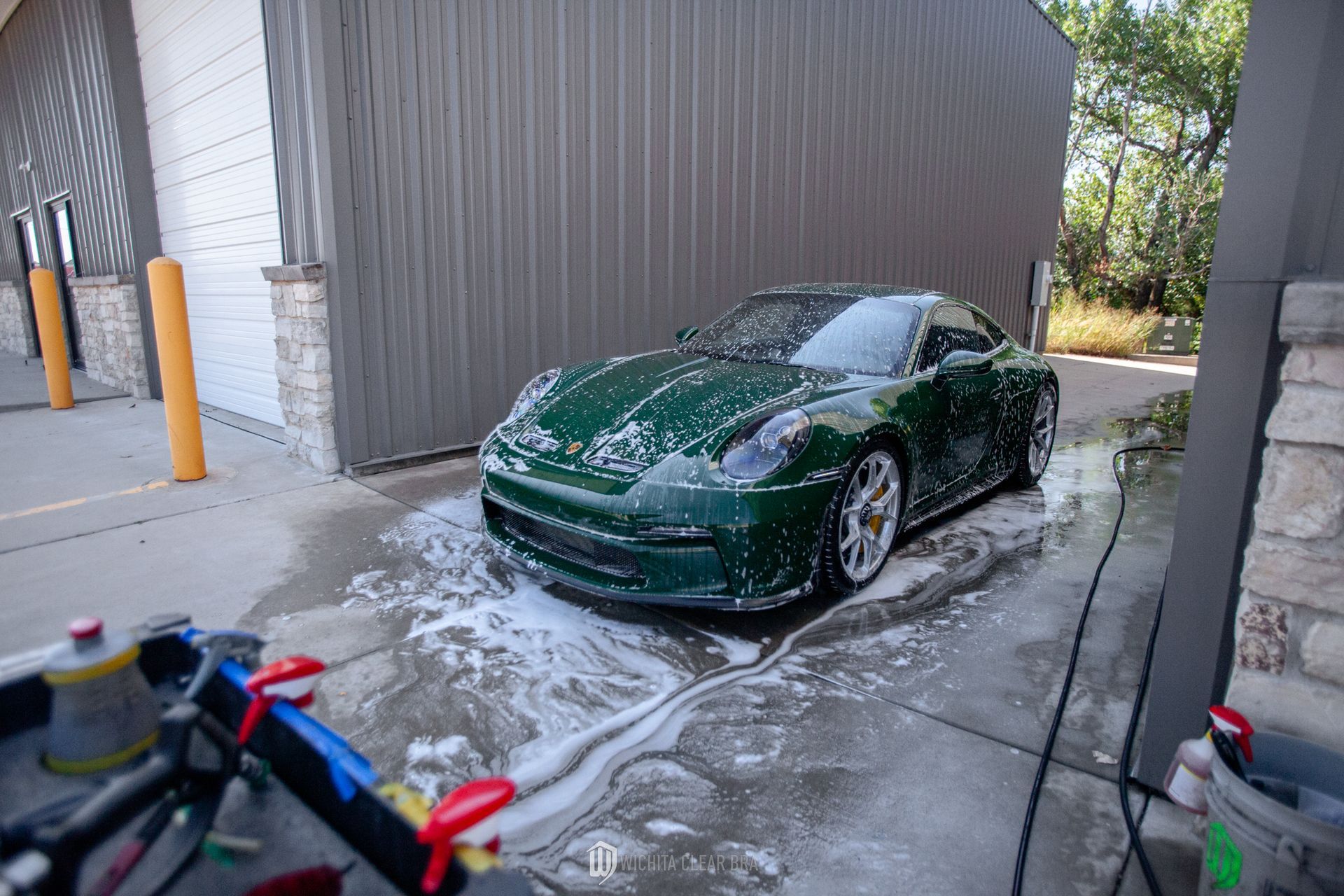 PTS British Racing Green 2024 Porsche 911 GT3 Touring covered in soap, being detailed and washed at Wichita Clear Bra in Wichita, KS