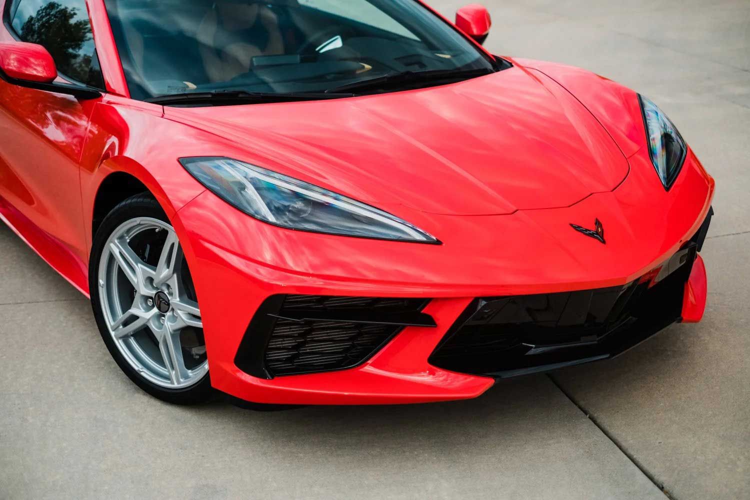 Red Chevrolet Corvette sports car parked on pavement.