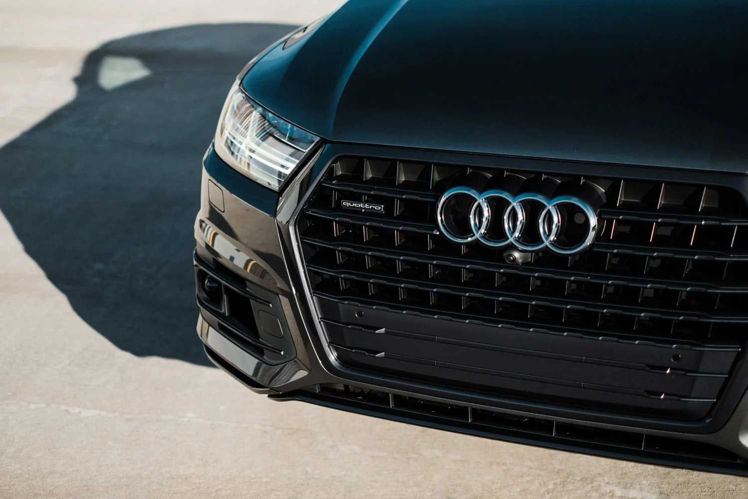 Black Audi car front grille, four rings logo.
