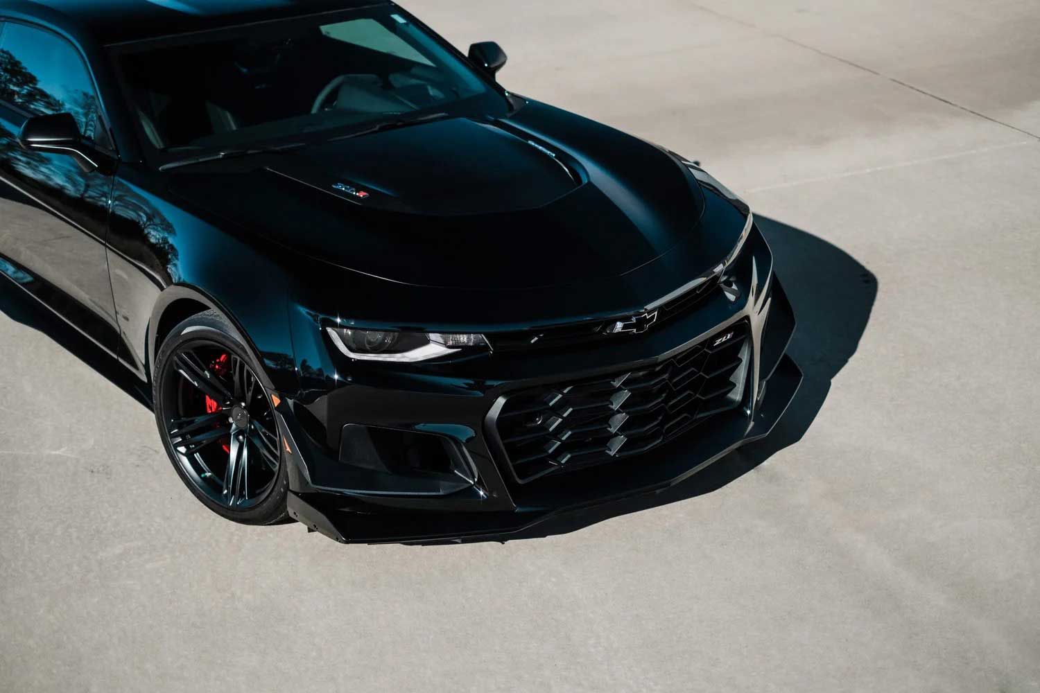 Black Chevrolet Camaro sports car on a light-colored surface, angled view.