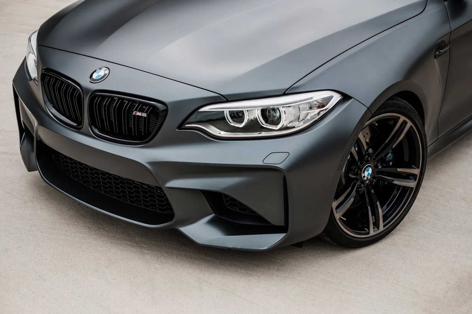 Gray BMW M2 coupe, front view, black grille and wheels.