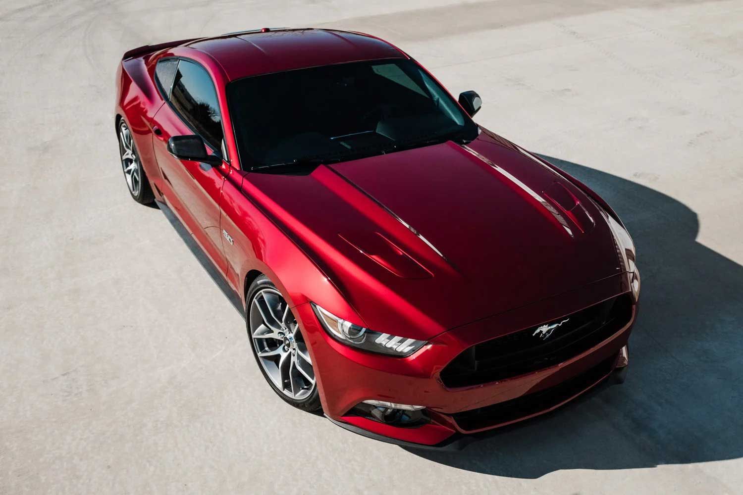 Red Ford Mustang parked on concrete.