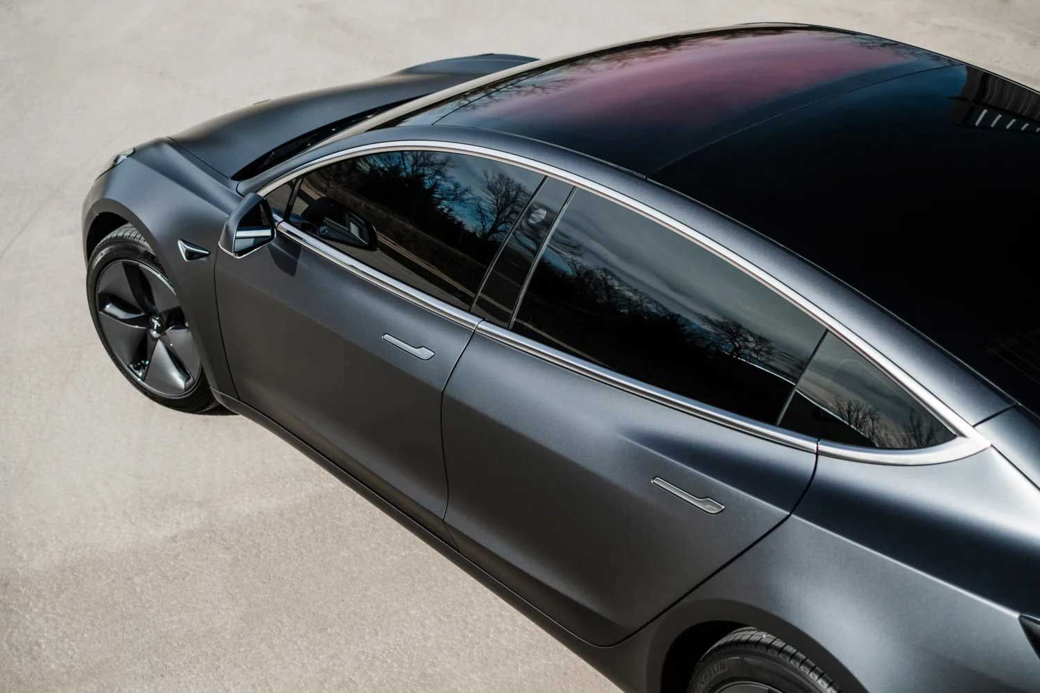 Gray Tesla Model 3 car on pavement.