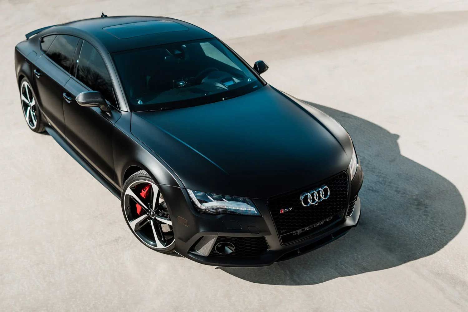 Black Audi RS7 sports car on a light-colored surface; red brake calipers.