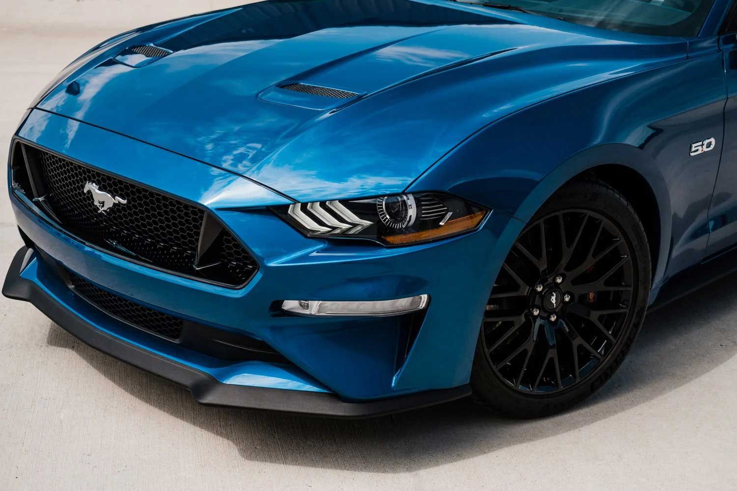 Blue Ford Mustang with black grill and wheels.