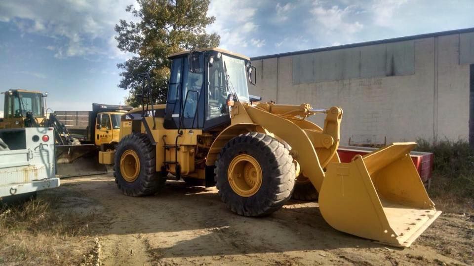 A yellow wheel loader is parked in front of a building.