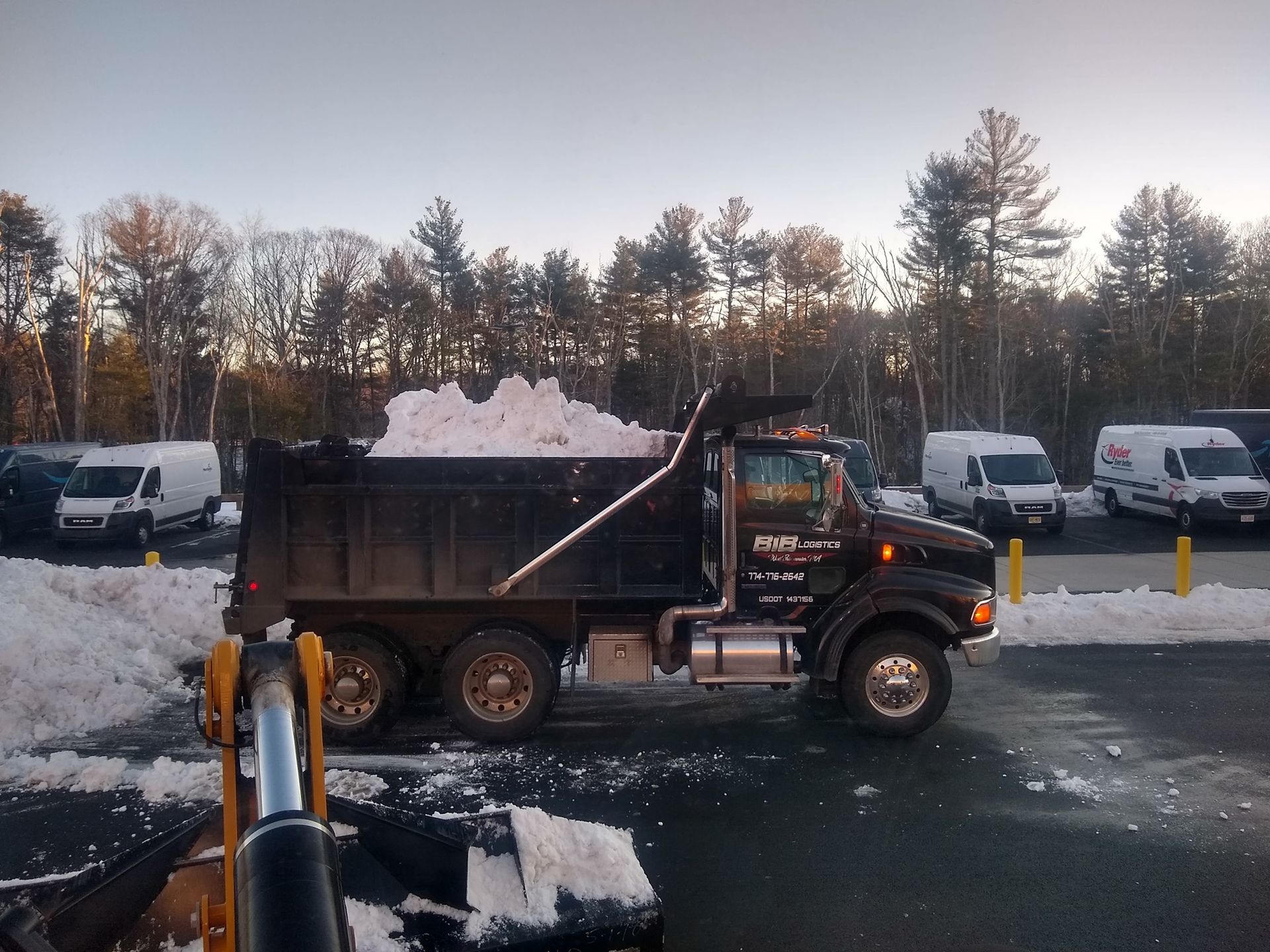A dump truck is loaded with snow in a parking lot